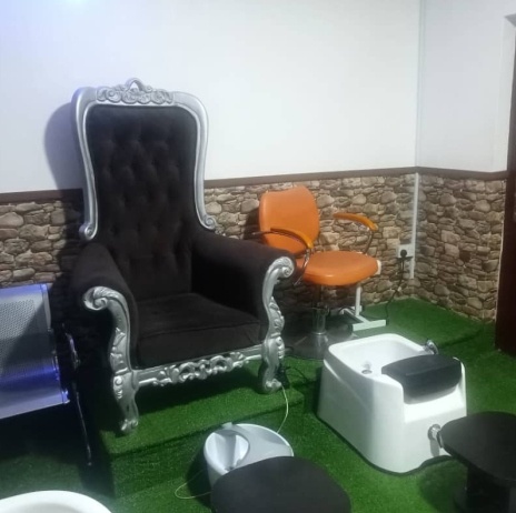Pedicure station with a silver throne chair and foot spa basin